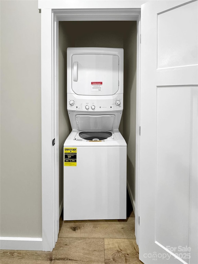 washroom featuring light hardwood / wood-style floors and stacked washer and dryer