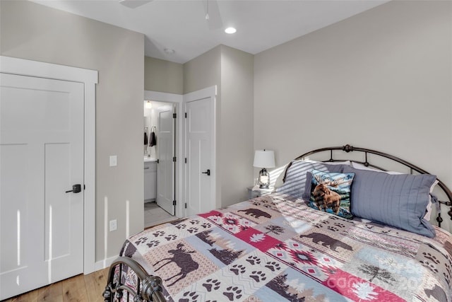 bedroom with ceiling fan, light hardwood / wood-style floors, and connected bathroom