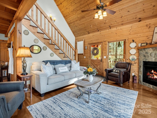 living room with ceiling fan, wooden walls, wood ceiling, and wood-type flooring