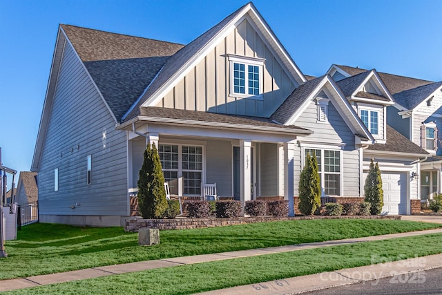 craftsman inspired home with a front lawn, a porch, and a garage