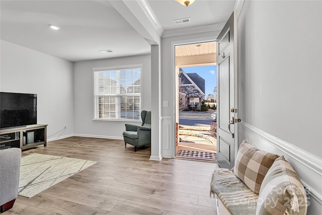 interior space with ornamental molding and light hardwood / wood-style flooring