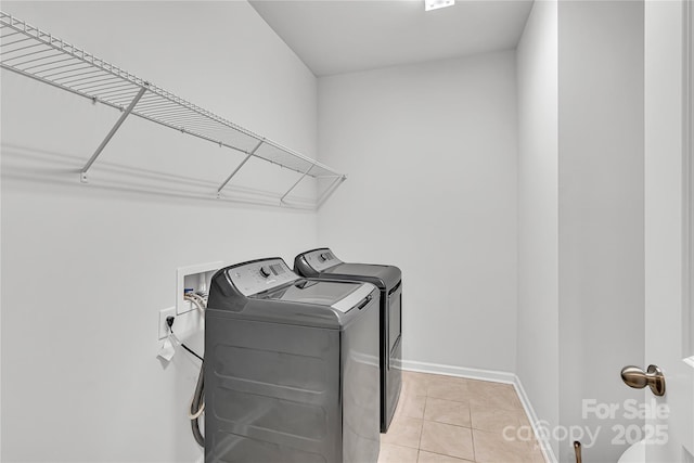 washroom featuring independent washer and dryer and light tile patterned flooring