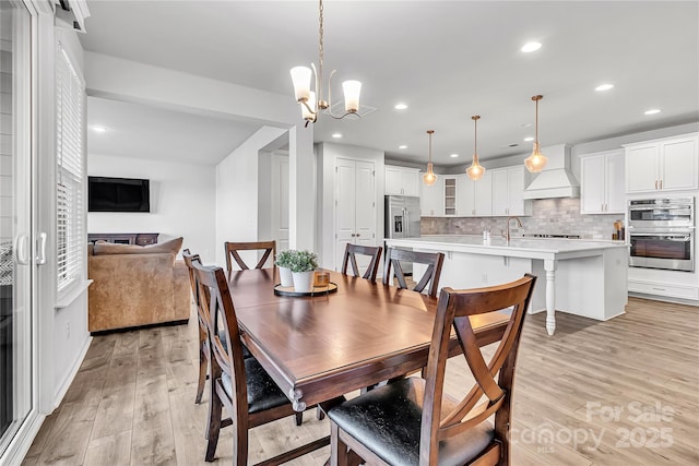 dining room featuring an inviting chandelier and light hardwood / wood-style floors