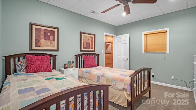 bedroom featuring ceiling fan, a drop ceiling, and carpet floors