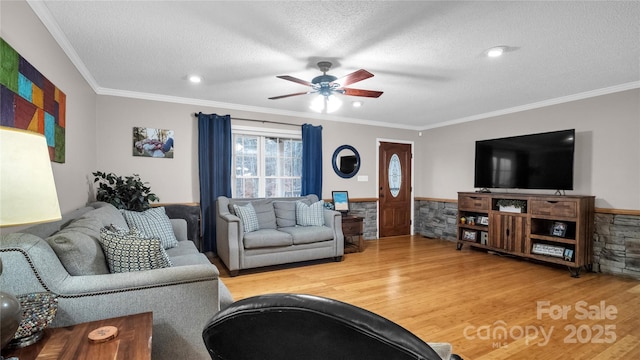 living room with crown molding, ceiling fan, a textured ceiling, and hardwood / wood-style flooring