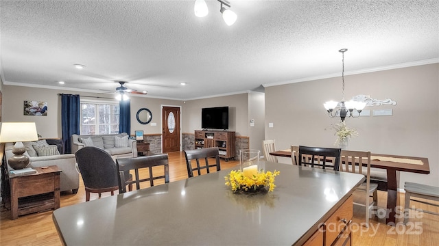 dining area featuring crown molding, light hardwood / wood-style flooring, and a textured ceiling