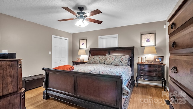 bedroom featuring ceiling fan, light hardwood / wood-style floors, a textured ceiling, and a closet