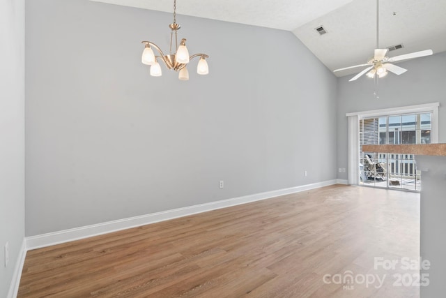 spare room with ceiling fan with notable chandelier, wood-type flooring, and lofted ceiling