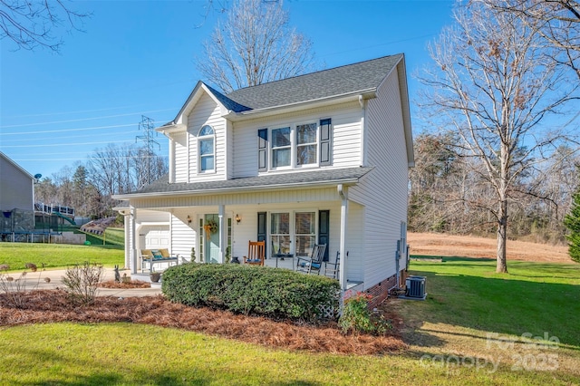 view of property featuring central air condition unit, a front lawn, and covered porch