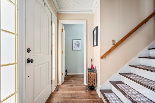 entryway with crown molding, dark hardwood / wood-style flooring, and a textured ceiling