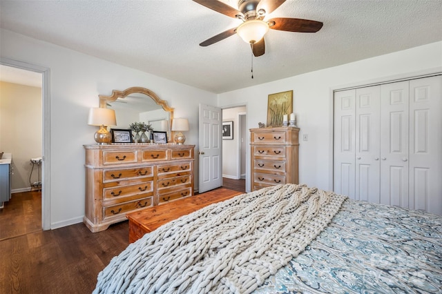 bedroom with ceiling fan, dark hardwood / wood-style flooring, a textured ceiling, and a closet