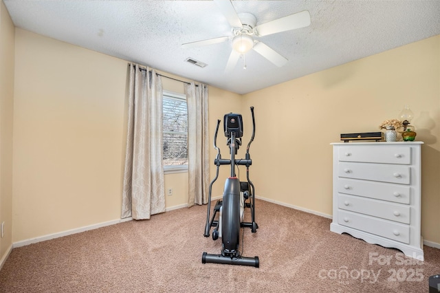 workout area featuring ceiling fan, carpet floors, and a textured ceiling