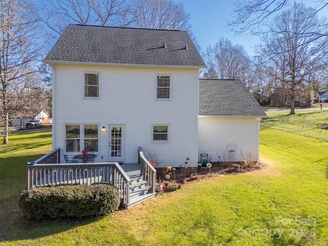 back of house featuring a lawn and a deck