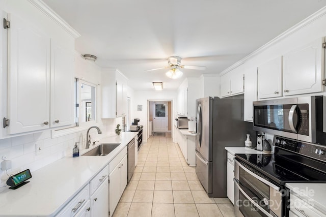 kitchen featuring appliances with stainless steel finishes, light tile patterned floors, sink, white cabinetry, and backsplash