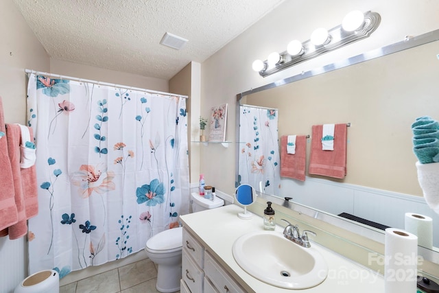 bathroom with toilet, a textured ceiling, tile patterned flooring, a shower with shower curtain, and vanity