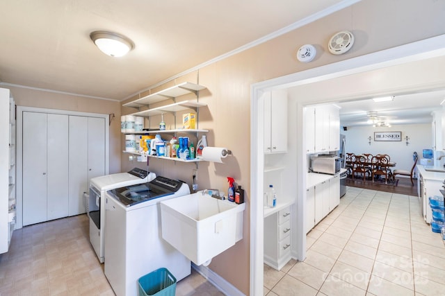 washroom featuring sink, ceiling fan, ornamental molding, and separate washer and dryer