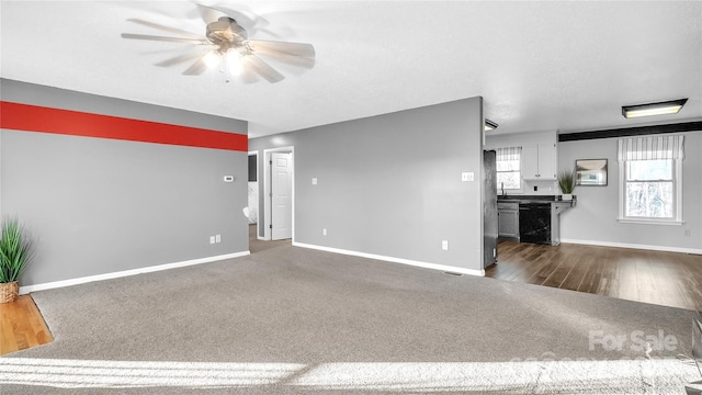 unfurnished living room featuring dark colored carpet and ceiling fan