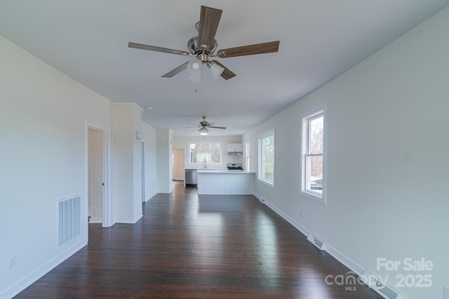 unfurnished living room featuring ceiling fan, sink, and dark wood-type flooring