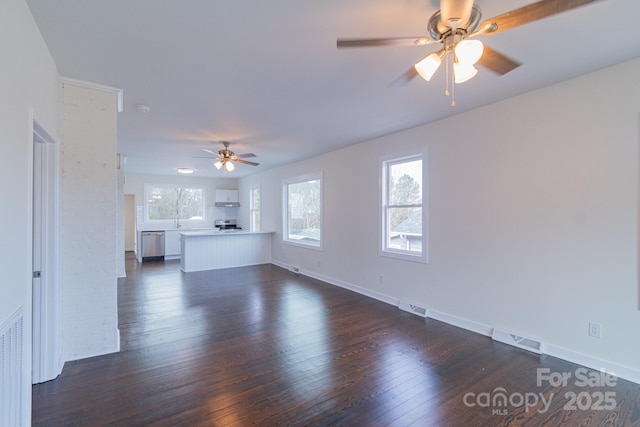 unfurnished living room featuring ceiling fan, sink, and dark wood-type flooring