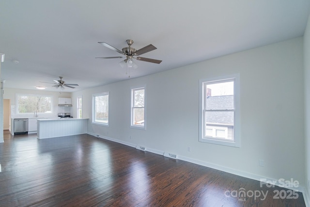 unfurnished living room with dark hardwood / wood-style flooring, ceiling fan, a healthy amount of sunlight, and sink