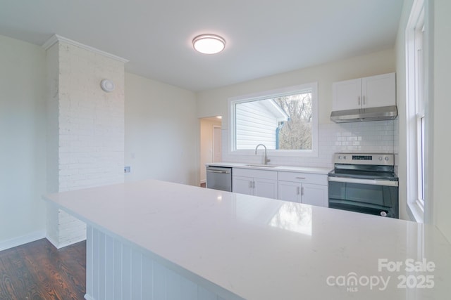 kitchen featuring backsplash, sink, appliances with stainless steel finishes, white cabinetry, and kitchen peninsula