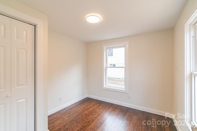 unfurnished room with dark hardwood / wood-style flooring