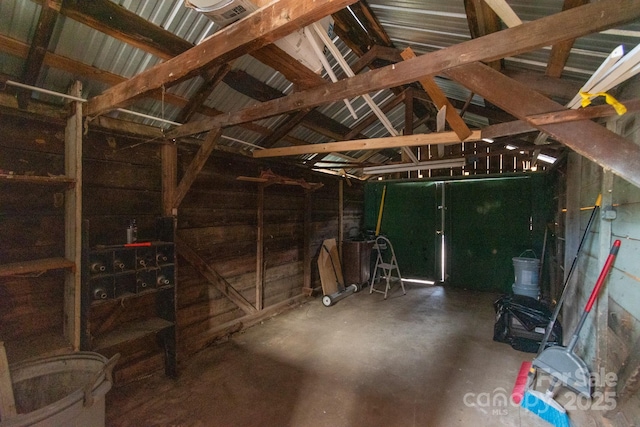 misc room with lofted ceiling and concrete flooring