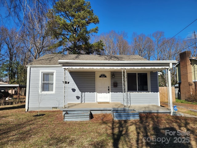 bungalow featuring covered porch and a front yard