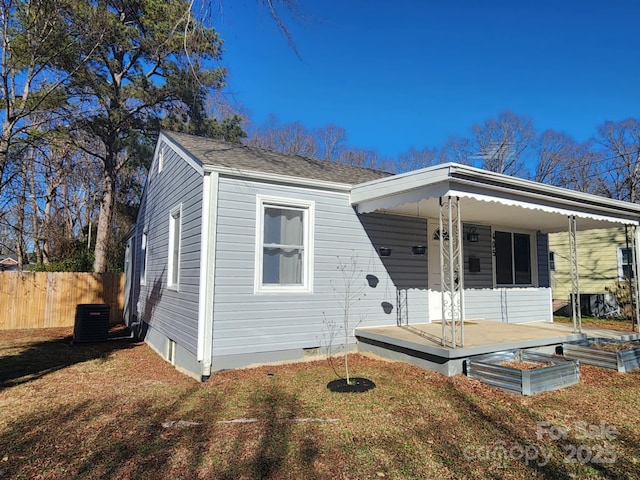 view of front of house with covered porch, central AC, and a front lawn