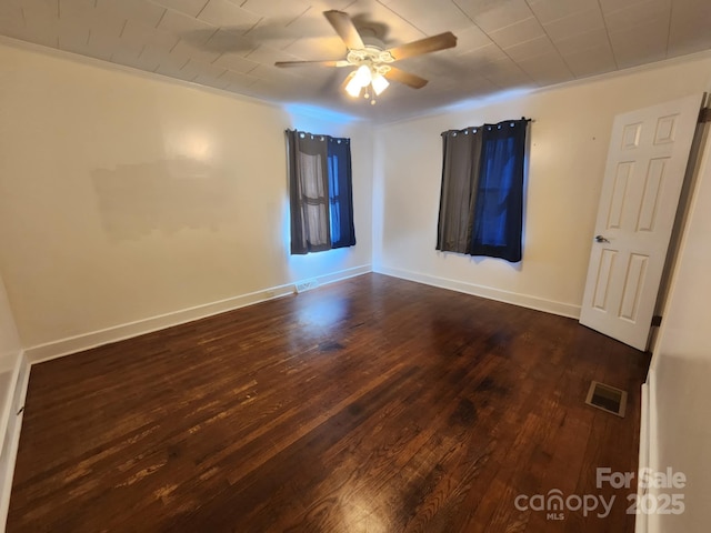 empty room featuring crown molding, dark hardwood / wood-style flooring, and ceiling fan