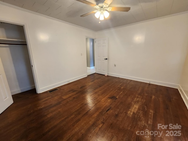 unfurnished bedroom with dark hardwood / wood-style flooring, a closet, ceiling fan, and ornamental molding