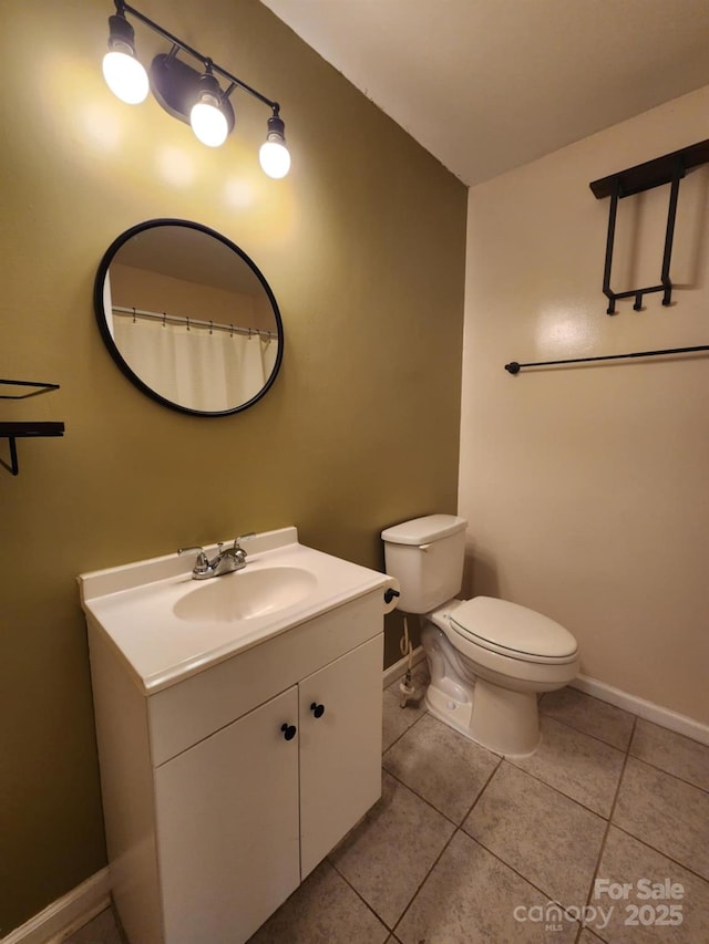 bathroom with toilet, vanity, and tile patterned floors