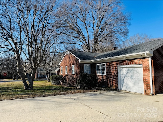 view of side of home featuring a garage and a lawn