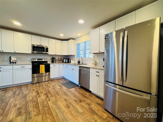 813 S Zion St, Landis, NC 28088 - kitchen with stainless steel appliances, white cabinetry, tasteful backsplash, light wood finished floors, and recessed lighting