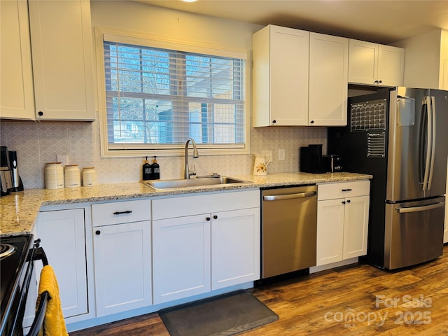 kitchen featuring tasteful backsplash, white cabinets, appliances with stainless steel finishes, and sink