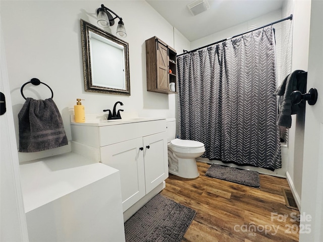 bathroom with toilet, a shower with shower curtain, wood-type flooring, and vanity