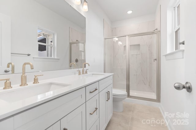 bathroom with a shower with door, vanity, tile patterned floors, and toilet