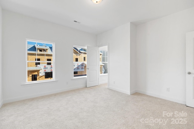 spare room featuring light colored carpet