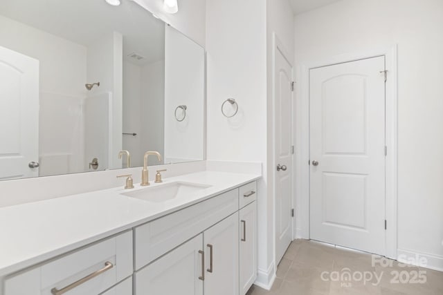 bathroom featuring vanity, tile patterned floors, and walk in shower