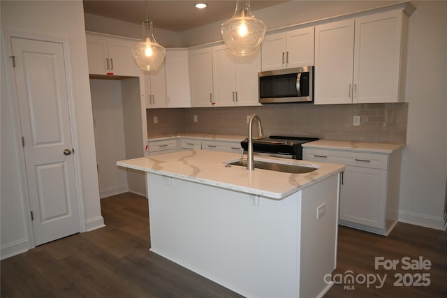 kitchen with stainless steel microwave, a sink, baseboards, and dark wood-style flooring