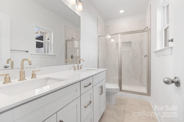bathroom with tile patterned floors, a marble finish shower, a sink, and toilet