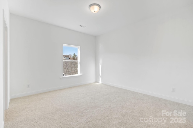 carpeted spare room with baseboards and visible vents