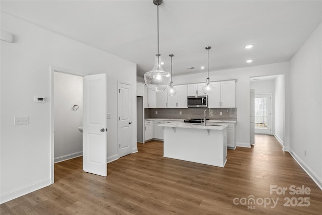 143 Cherry Springs Ln Unit 13-C, Asheville, NC 28804 - kitchen with stainless steel microwave, white cabinetry, light countertops, tasteful backsplash, and recessed lighting