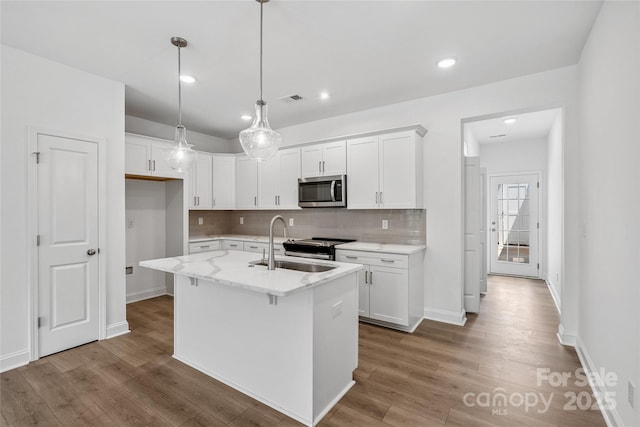 143 Cherry Springs Ln Unit 13-C, Asheville, NC 28804 - kitchen featuring stainless steel appliances, backsplash, white cabinetry, wood finished floors, and an island with sink