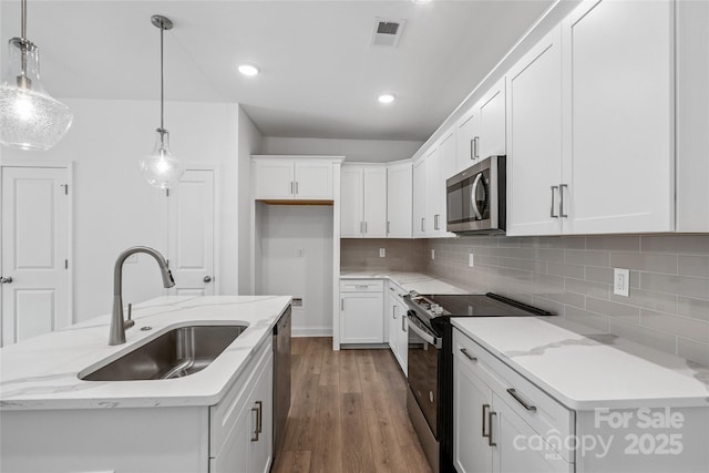 143 Cherry Springs Ln Unit 13-C, Asheville, NC 28804 - kitchen with stainless steel appliances, wood finished floors, decorative backsplash, white cabinetry, and recessed lighting