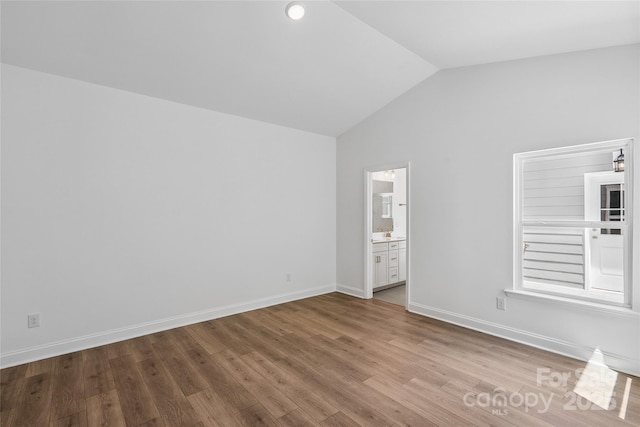 143 Cherry Springs Ln Unit 13-C, Asheville, NC 28804 - unfurnished bedroom featuring vaulted ceiling, wood finished floors, and ensuite bathroom
