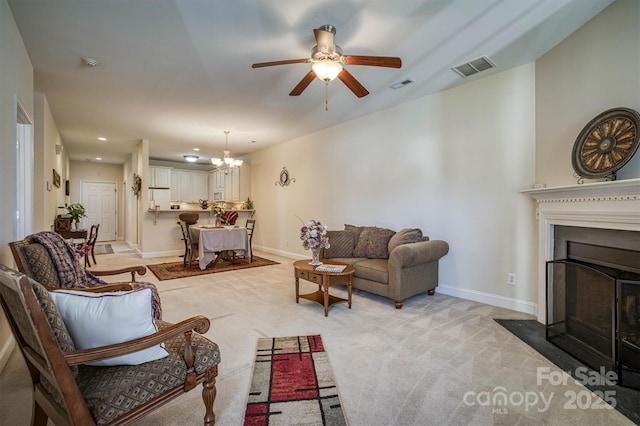 living room featuring ceiling fan with notable chandelier and light colored carpet