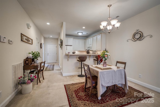 carpeted dining area with a notable chandelier