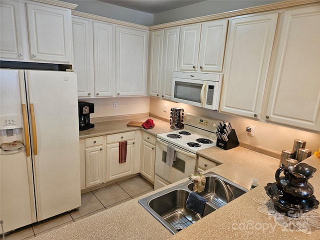 kitchen featuring light tile patterned floors, white appliances, white cabinetry, and sink