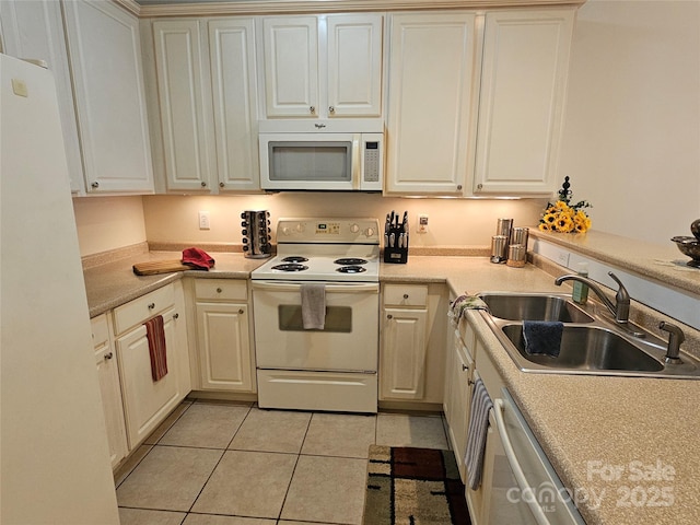 kitchen featuring white cabinets, light tile patterned floors, white appliances, and sink